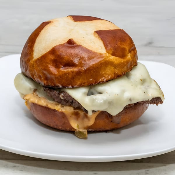 Rock Burger's cheeseburger with melted white cheese and special sauce on a pretzel bun.